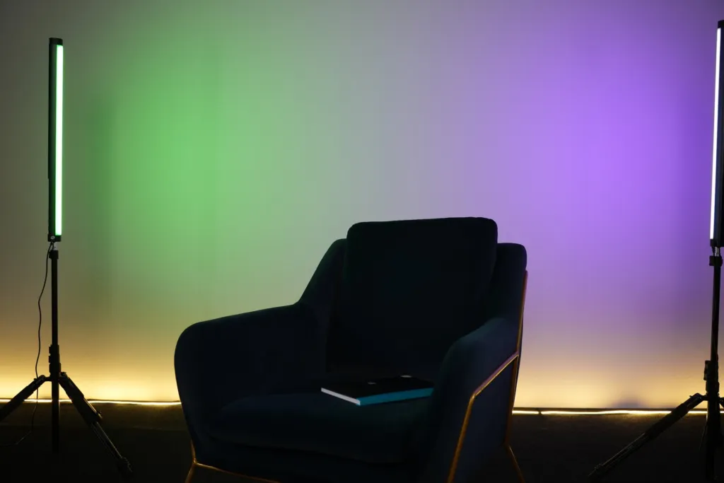 Décor béton avec fauteuil, tubes LED et bandeau lumineux au sol