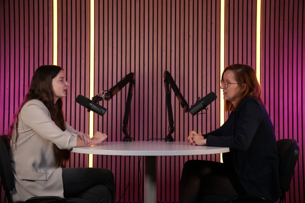 Podcast à deux autour de la table ronde, décor tasseaux bois et micros sur bras articulés